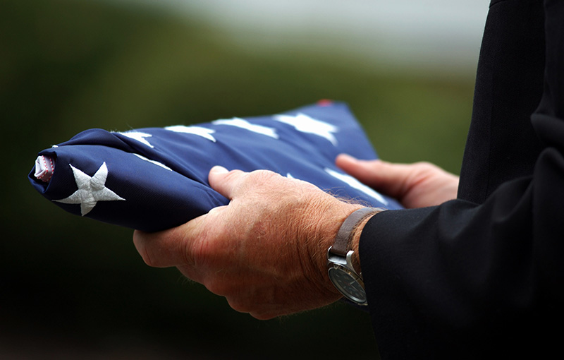 Man's hands holding a folded American flag